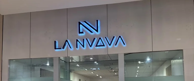 The lit La Nuova sign above the store entrance inside Palisades Center